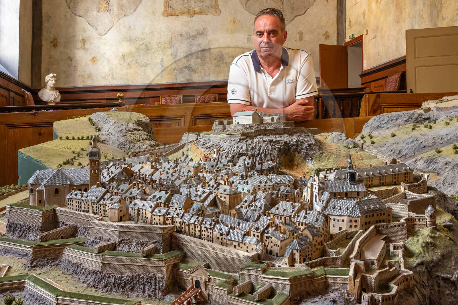 Eric Peythieu, adjoint au maire en charge du patrimoine avec la copie du plan-relief de Briançon conservée dans la salle d’audience de l’ancien tribunal